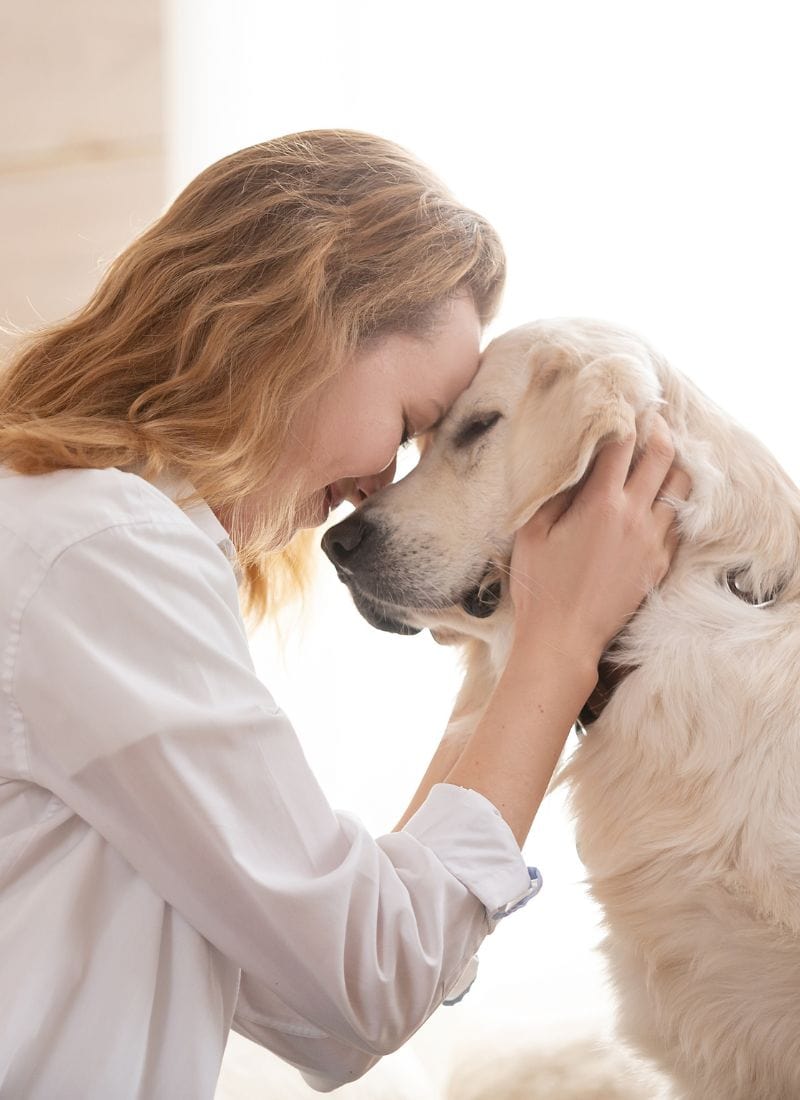 dog and woman with heads together